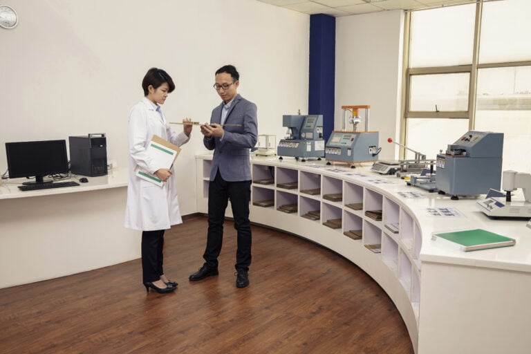 Technician explaining print product to manager in printing and packaging factory, China
